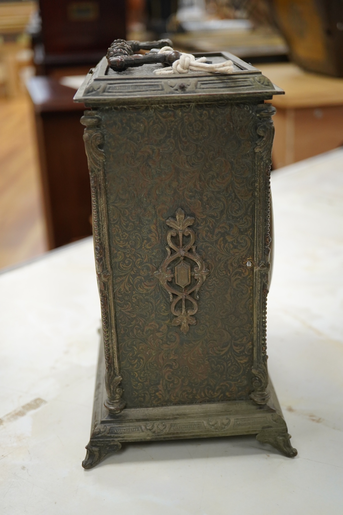 A brass overlaid mantel clock with key and pendulum, striking on a bell, 26cm high